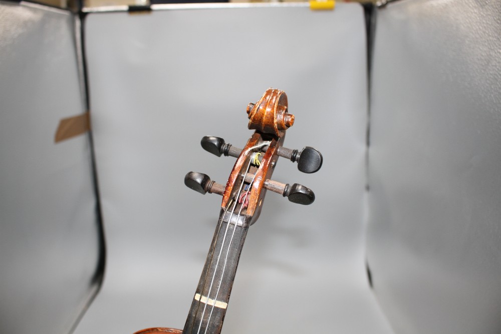 A violin with two piece back and bow, and a childs violin with bow, both with cases